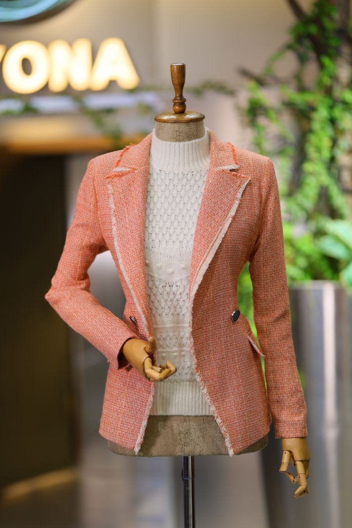 Services-02 Stylish pink blazer displayed on mannequin in a modern boutique with vibrant decor.