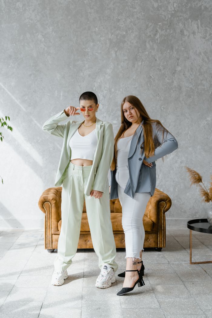 The Art of Drawing Readers In: Your attractive post title goes here Two women in stylish outfits confidently posing in a modern indoor setting.